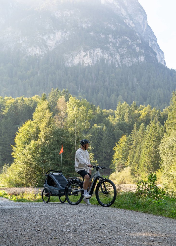 Cyclist with a Qeridoo child bicycle trailer in the mountains